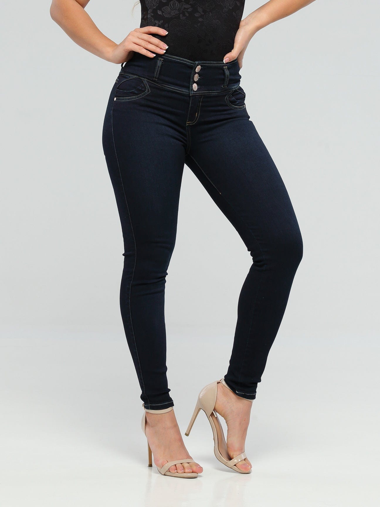 High waist, dark blue, skinny jeans worn by a model in heels