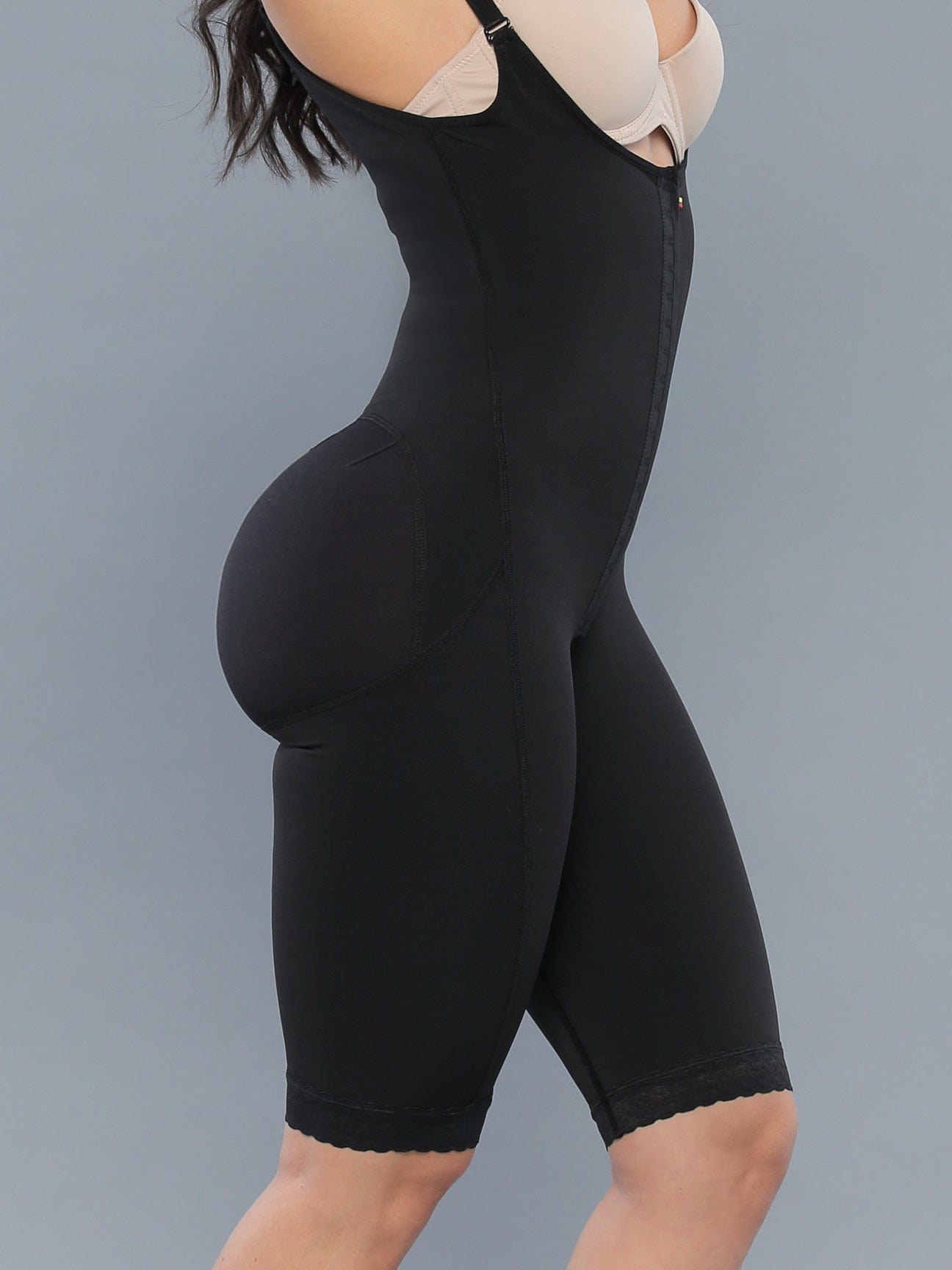 Black Colombian faja bodysuit with butt-lifting panels and full thigh support, side view