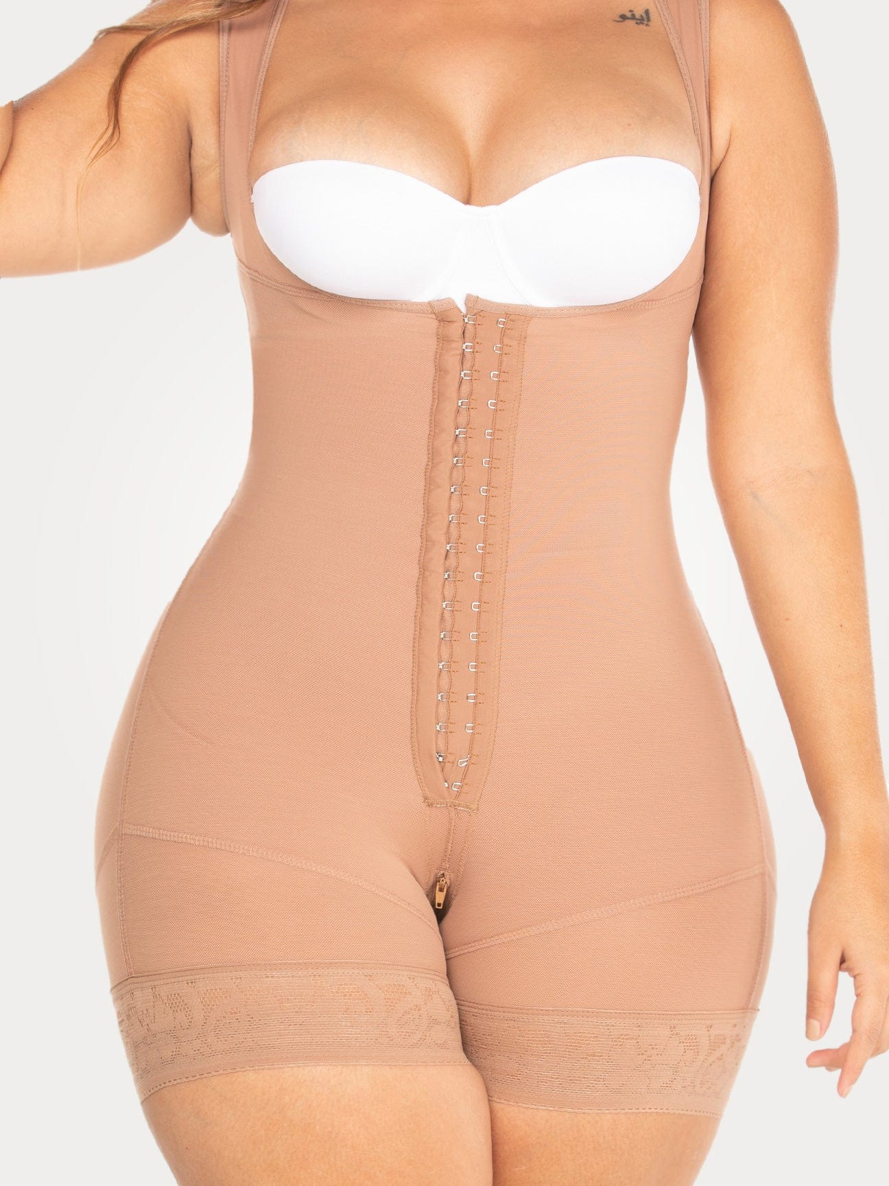Nude Colombian faja shapewear bodysuit with adjustable hook-and-eye closure and firm waist compression, front view