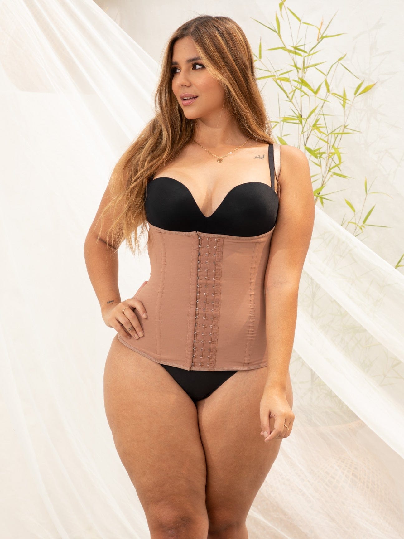 Plus sized model wearing a brown colored strapless shapewear.