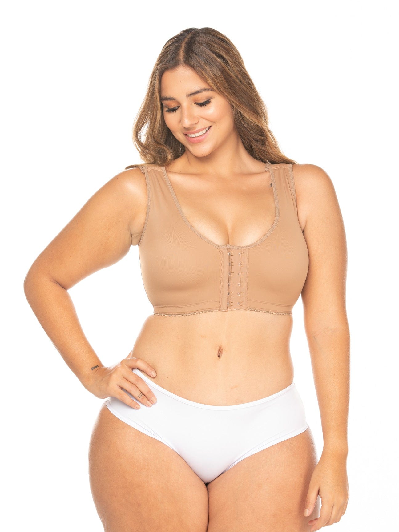 Full body view of a model wearing the shapewear bra with central hooks.